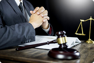 A table infront of judge having a gavel,papers and a court balance - Leckerman Law, LLC