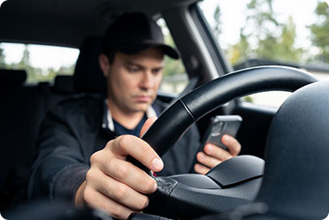 A man is using mobile while driving - Leckerman Law, LLC