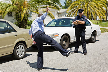 A policeman inspecting a person on a road - Leckerman Law, LLC