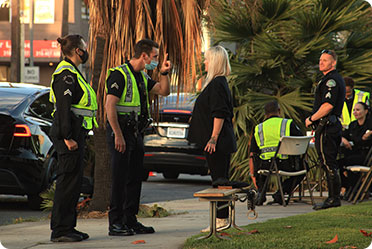 Police officers talking to people on the sidewalk - Leckerman Law, LLC
