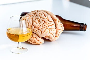 A glass of beer empty bottle and a brain-shape structure - Leckerman Law, LLC