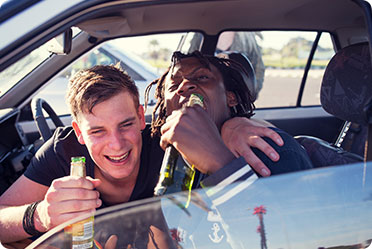 Two men in a car drinking beer - Leckerman Law, LLC