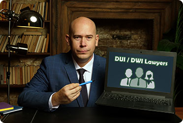 A professional man in a suit holds a pen and laptop displaying the words 