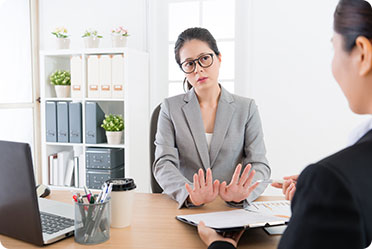 A woman in a business suit conversing with another woman - Leckerman Law, LLC