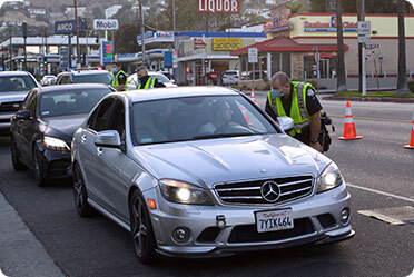 A police officer inspecting a person sitting in a car - Leckerman Law, LLC