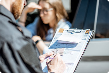 A policeman is checking the documents of a lady driver - Leckerman Law, LLC