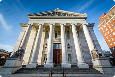A grand white building with majestic columns and pillars - Leckerman Law, LLC