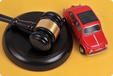 A red small car and a gavel - Leckerman Law, LLC