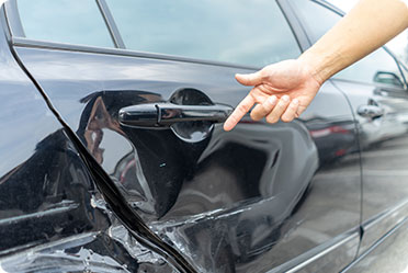 A dent on a black car - Leckerman Law, LLC