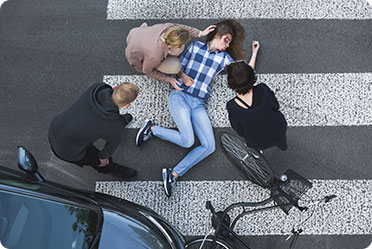 A lady lying on the ground in a crosswalk, possibly injured or unconscious - Leckerman Law, LLC