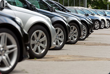 A line of parked cars in a parking lot - Leckerman Law, LLC