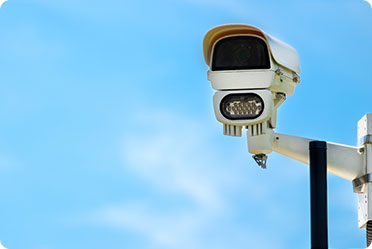 A security camera against a blue sky - Leckerman Law, LLC