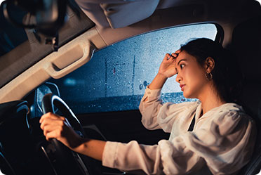 A woman driving a car at night - Leckerman Law, LLC