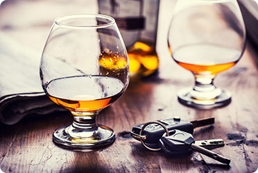 Two glasses of alcohol and keys on a table - Leckerman Law, LLC