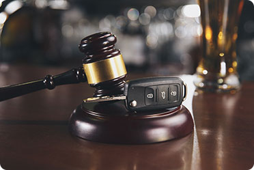 A wooden table with a gavel and car keys - Leckerman Law, LLC