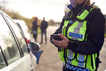 A police officer standing next to a car - Leckerman Law, LLC