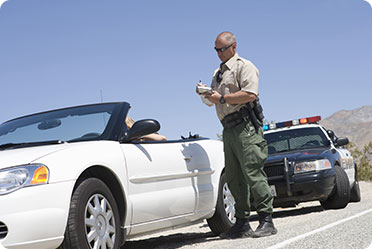 A police officer standing beside a car - Leckerman Law, LLC